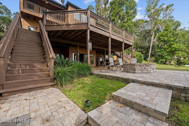 rear view of property with a wooden deck, a yard, and a patio area