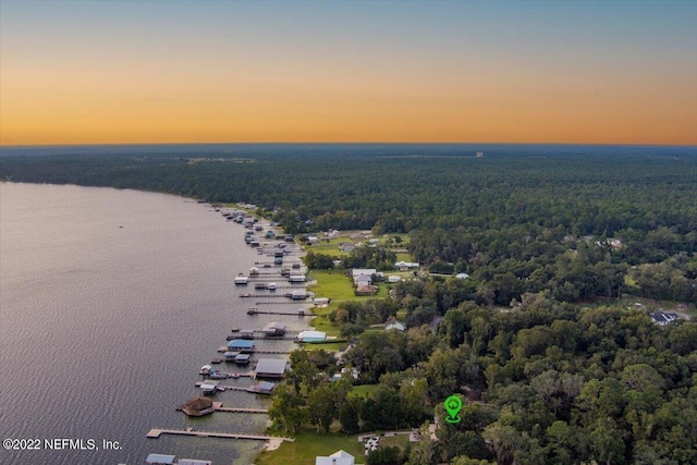 aerial view at dusk featuring a water view