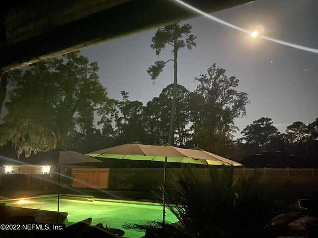 view of pool at twilight