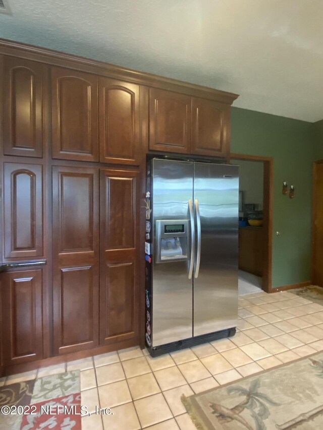 kitchen with stainless steel fridge with ice dispenser and light tile patterned floors