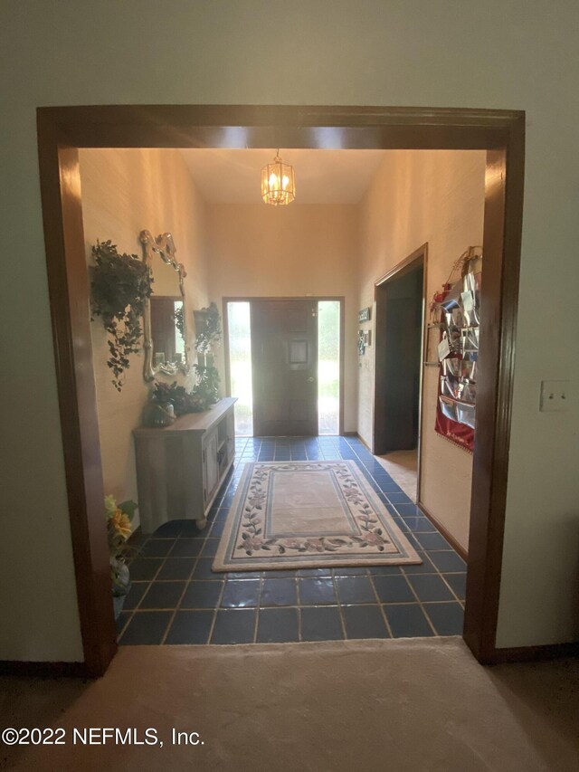 interior space with a chandelier and dark tile patterned floors