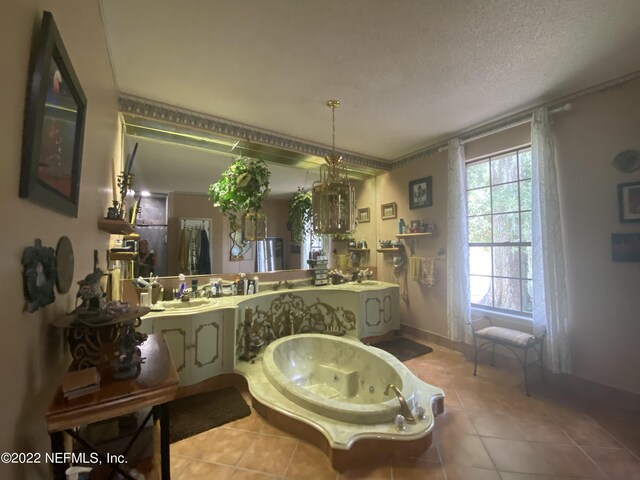 bathroom featuring a textured ceiling, sink, and tile patterned floors