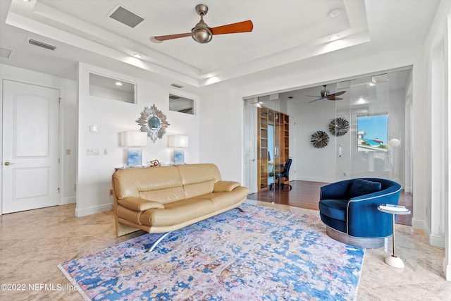 living room featuring a raised ceiling and light wood-type flooring