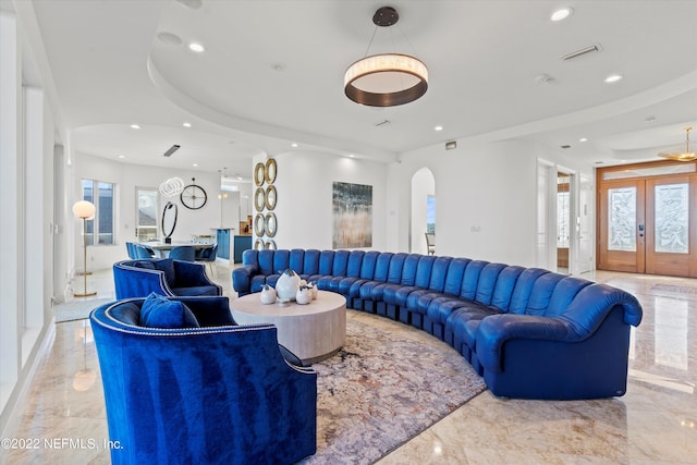 living room featuring a raised ceiling and french doors