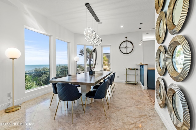 dining room with a chandelier, a water view, and a healthy amount of sunlight