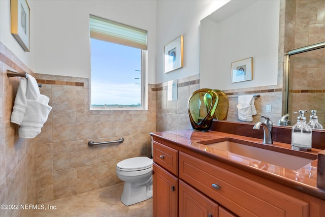 bathroom with tile patterned flooring, vanity, toilet, and tile walls