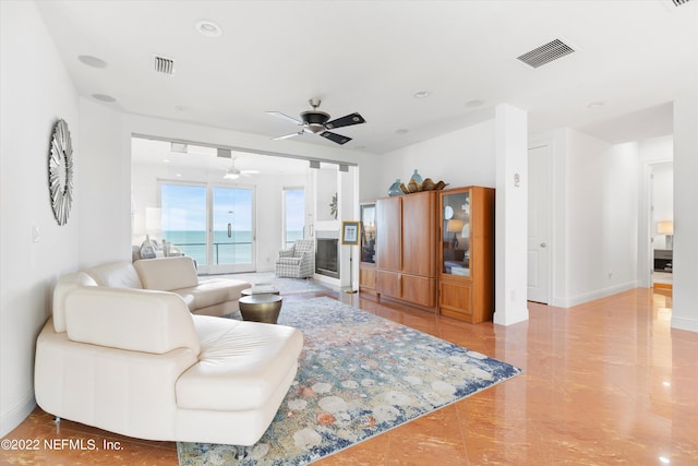 living room with ceiling fan and a water view