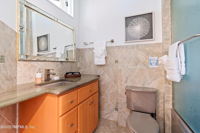 bathroom featuring vanity, tile walls, and toilet