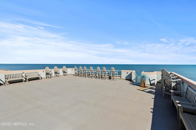 view of patio with a water view and a view of the beach