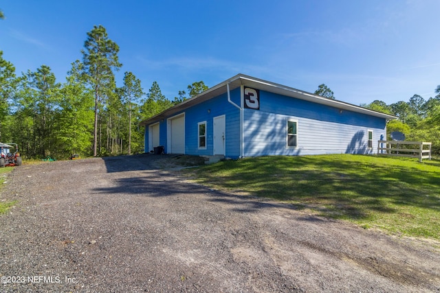 view of side of property with a lawn and a garage