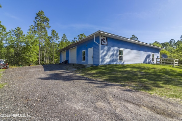 view of property exterior featuring a garage and a yard