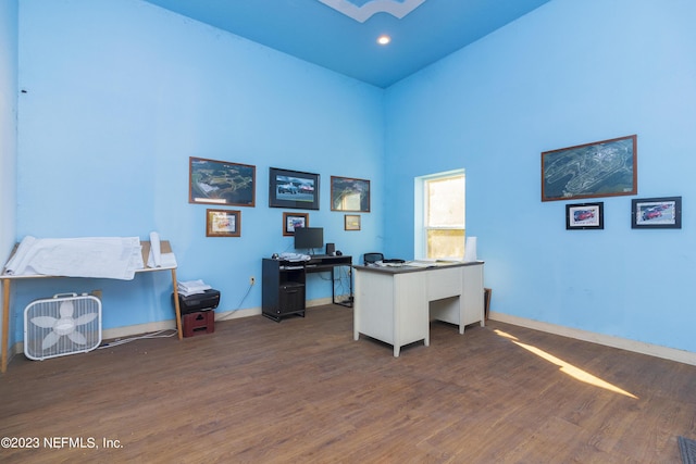 office featuring dark hardwood / wood-style flooring and a high ceiling