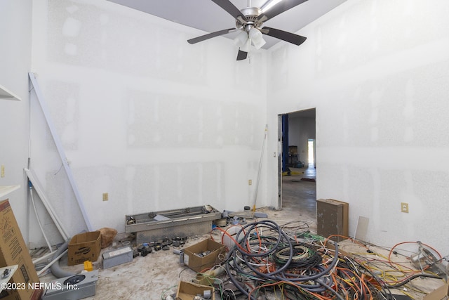 interior space featuring ceiling fan and a high ceiling