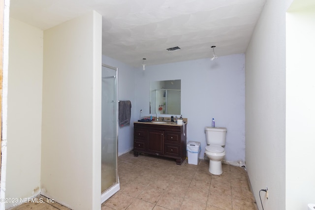 bathroom featuring vanity, a shower with shower door, and toilet