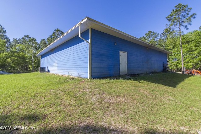 view of side of property with a yard and central AC unit