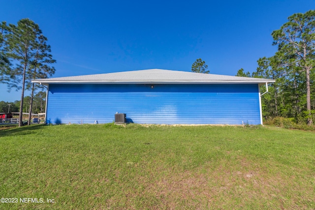 view of home's exterior with cooling unit and a lawn