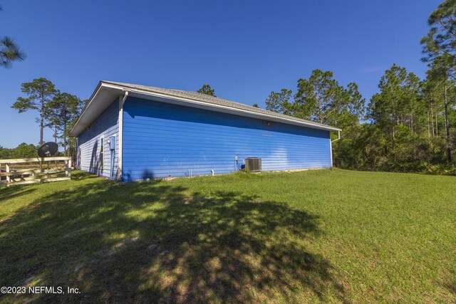 view of side of property featuring a yard and cooling unit