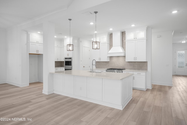 kitchen with light hardwood / wood-style flooring, white cabinets, custom exhaust hood, and stove