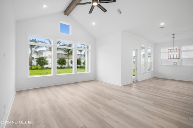 unfurnished living room with light wood finished floors, plenty of natural light, visible vents, and beamed ceiling