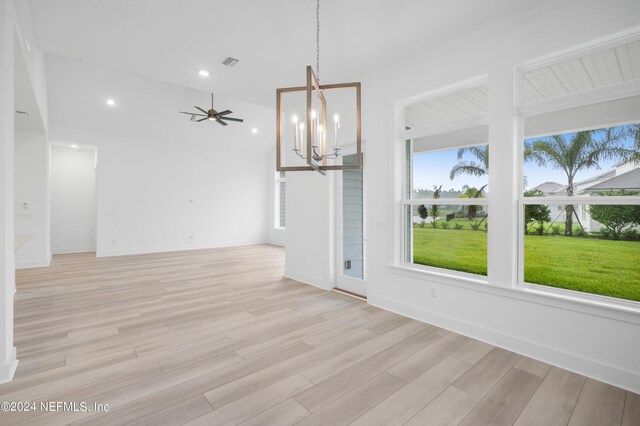 interior space featuring light wood-type flooring and ceiling fan with notable chandelier