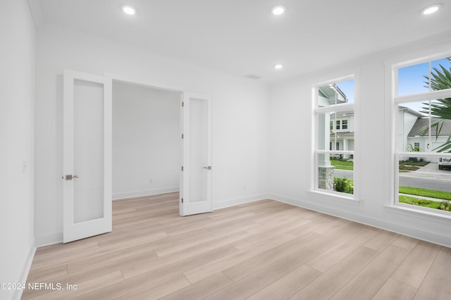 empty room featuring recessed lighting, visible vents, light wood-style floors, ornamental molding, and baseboards