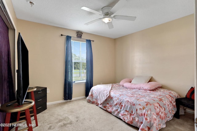 bedroom with a closet, ceiling fan, light colored carpet, and a textured ceiling