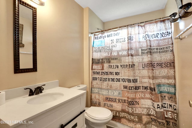 bathroom featuring a shower with curtain, vanity, and toilet