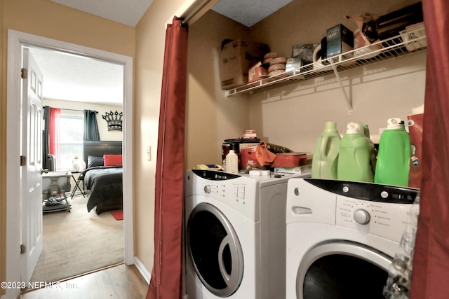 laundry room featuring separate washer and dryer and light colored carpet