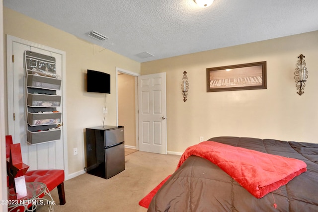 carpeted bedroom with a textured ceiling and stainless steel fridge