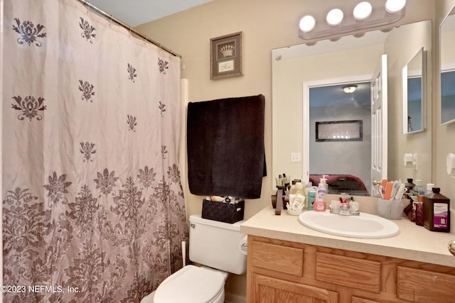 bathroom featuring curtained shower, vanity, and toilet