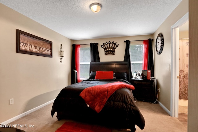 bedroom with multiple windows, ensuite bath, and light carpet