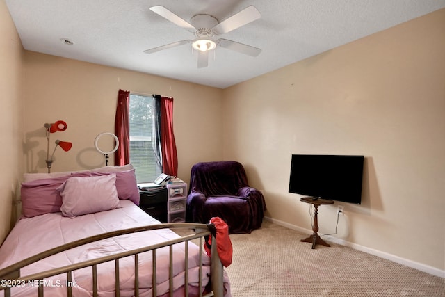 bedroom featuring ceiling fan, carpet flooring, and a textured ceiling