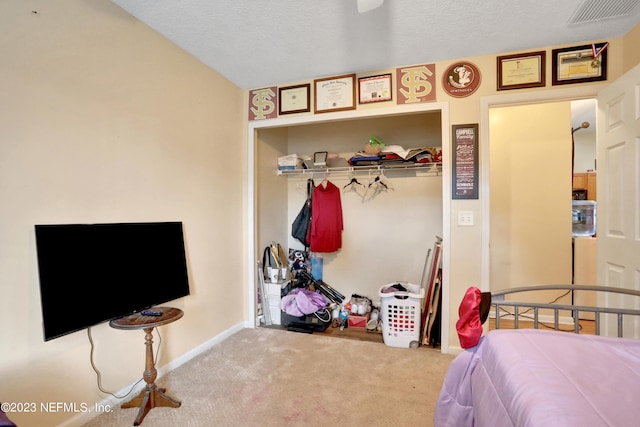 carpeted bedroom featuring a textured ceiling and a closet