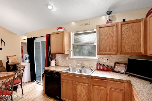 kitchen with black dishwasher, light wood-type flooring, backsplash, and sink