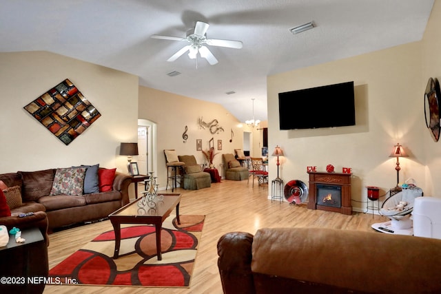 living room featuring ceiling fan with notable chandelier, vaulted ceiling, and hardwood / wood-style floors