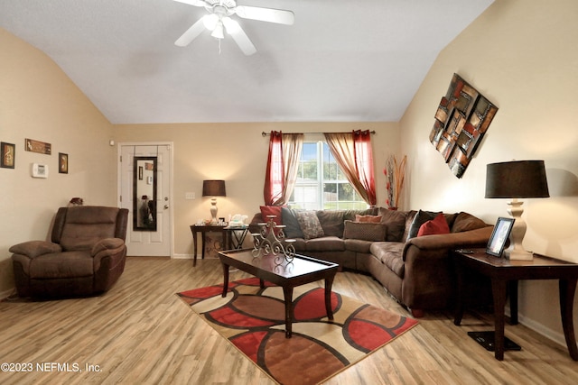 living room featuring ceiling fan, light hardwood / wood-style floors, and vaulted ceiling