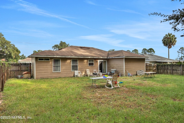 rear view of house with a yard