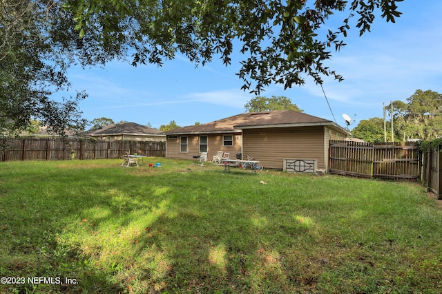 back of house featuring a lawn