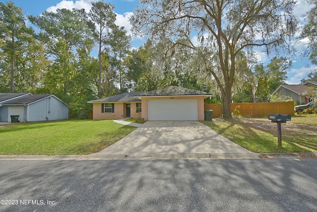 view of front of house with concrete driveway, an attached garage, fence, a front yard, and stucco siding