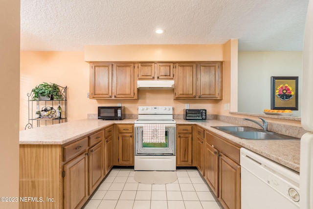 kitchen featuring kitchen peninsula, white appliances, sink, and a textured ceiling