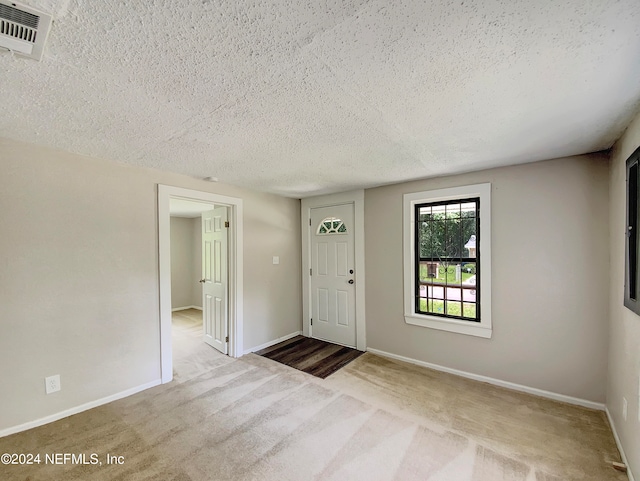 entryway with a textured ceiling and carpet floors