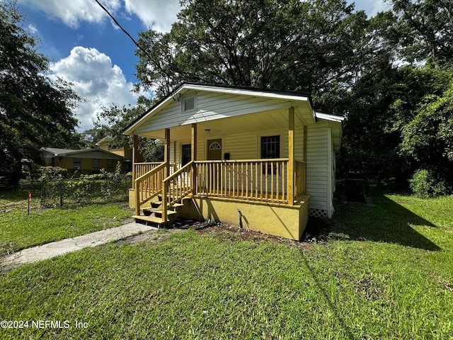 bungalow with covered porch and a front yard