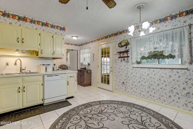 kitchen with hanging light fixtures, sink, light tile patterned floors, and white dishwasher