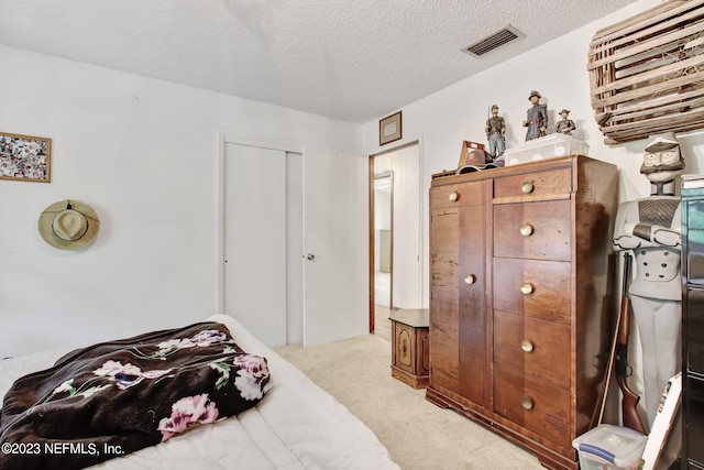 carpeted bedroom with a closet and a textured ceiling