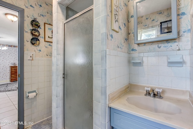 bathroom with vanity, tile walls, and a shower with shower door