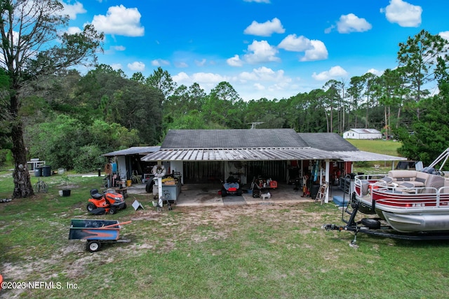 exterior space featuring an outbuilding, a carport, and a front yard