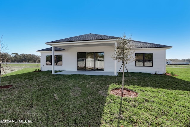 rear view of property with a yard and a patio