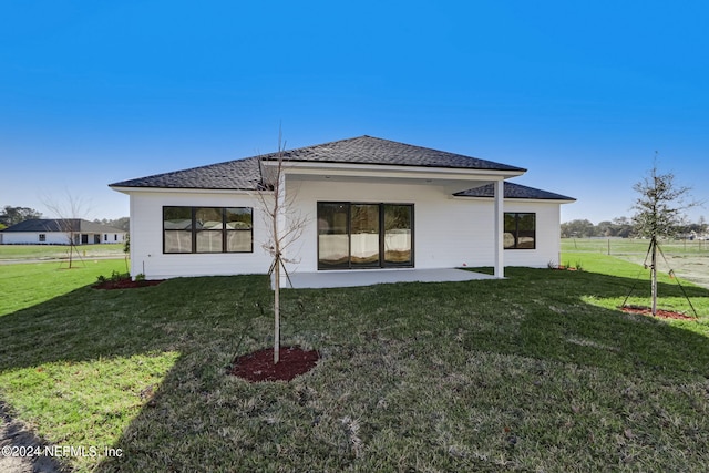 rear view of house with a lawn and a patio area