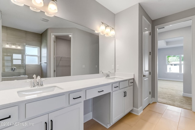 bathroom featuring tile patterned floors, a shower with door, and vanity