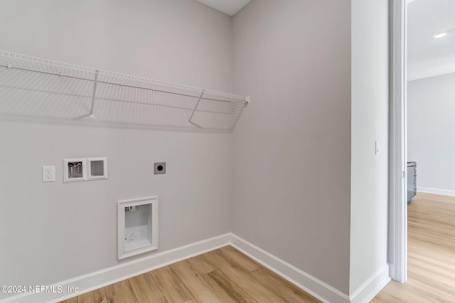 clothes washing area with hookup for an electric dryer, hardwood / wood-style flooring, and hookup for a washing machine